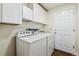 Functional laundry room with washer, dryer, and overhead cabinets at 13668 Plaster Cir, Broomfield, CO 80023