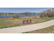 Scenic water view with bench along a paved walkway with mature trees and foliage at 13668 Plaster Cir, Broomfield, CO 80023
