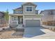 Charming two-story home featuring a covered porch, two-car garage, and appealing gray siding at 10984 Snowdon St, Parker, CO 80134