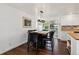 This dining area features a wood table with black chairs and a modern chandelier with access to the kitchen and sunroom at 13472 W Dakota Ave, Lakewood, CO 80228