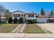 Charming two-story home with landscaped front yard and attached two-car garage on a sunny day at 13472 W Dakota Ave, Lakewood, CO 80228