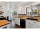 This kitchen features white cabinets with a brick backsplash, butcher block countertops and stainless steel appliances at 13472 W Dakota Ave, Lakewood, CO 80228