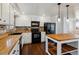 The kitchen features white cabinets, black appliances, butcher block countertops, brick backsplash and a center island at 13472 W Dakota Ave, Lakewood, CO 80228