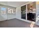 Enclosed porch with gray carpet and white walls leading to a dining room with wood floors at 13472 W Dakota Ave, Lakewood, CO 80228