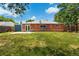 Spacious backyard featuring a well-maintained lawn and a charming brick home exterior at 9320 Fir Dr, Thornton, CO 80229