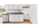 The kitchen has white cabinets, stainless appliances, granite countertops, and wood floors at 9320 Fir Dr, Thornton, CO 80229