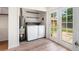 Functional laundry room with washer, dryer, shelves, and exterior access to the backyard at 9320 Fir Dr, Thornton, CO 80229