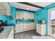 Cozy kitchen featuring white cabinets, blue tile backsplash, and stainless steel appliances at 3310 W Mountain Rd, Englewood, CO 80110