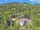 Aerial view of home surrounded by green trees with a mountain in the background at 9092 Gray Ln, Conifer, CO 80433