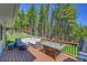 Spacious wooden deck featuring a comfortable seating arrangement and a grill at 9092 Gray Ln, Conifer, CO 80433
