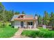 Charming home featuring a copper roof, gray door, and wooden deck perfect for enjoying the outdoors at 9092 Gray Ln, Conifer, CO 80433