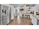 Well-lit kitchen with stainless steel appliances, white cabinets, breakfast bar seating, and hardwood floors at 9092 Gray Ln, Conifer, CO 80433