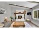 Bright living room showcasing a stone fireplace with a wooden mantle, hardwood floors, and a neutral color palette at 9092 Gray Ln, Conifer, CO 80433