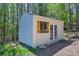 Exterior view of a well maintained outbuilding with charming window shutters at 9092 Gray Ln, Conifer, CO 80433