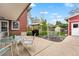 Spacious backyard patio with a dining area, grill, swing, and lush greenery at 2210 Miller St, Lakewood, CO 80215