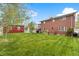 A well-maintained backyard with a lush lawn, red outbuilding, and a charming gazebo at 2210 Miller St, Lakewood, CO 80215