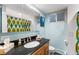 This full bathroom offers black granite counters, a modern vanity and ample natural light at 2210 Miller St, Lakewood, CO 80215