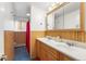 Bathroom featuring double sinks, a mirror and shower with a red curtain at 2210 Miller St, Lakewood, CO 80215