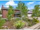 An inviting two-story brick home with lush landscaping and vibrant greenery enhancing its curb appeal at 2210 Miller St, Lakewood, CO 80215