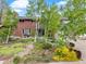 Beautiful two-story brick home with manicured lawn, mature trees, and colorful landscaping at 2210 Miller St, Lakewood, CO 80215