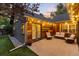 Charming back patio features ample seating, string lights, and unique wood detailing at dusk at 1392 W Caley Ave, Littleton, CO 80120