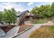 Well-manicured backyard featuring mature trees, a garden area, upper deck, and a gravel pathway at 1392 W Caley Ave, Littleton, CO 80120