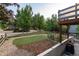 Landscaped backyard with garden beds, artificial turf, split rail fence, and a view of the house at 1392 W Caley Ave, Littleton, CO 80120