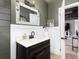 Updated bathroom with a wood vanity, white countertops, white wainscoting, gray walls, and wood look floors at 1392 W Caley Ave, Littleton, CO 80120