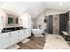 A modern bathroom features a soaking tub, large glass shower, and double vanity with black countertops at 1392 W Caley Ave, Littleton, CO 80120