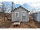 View of shed featuring a light gray exterior, green trim, and a small patio at 13581 Sable Blvd, Brighton, CO 80601