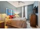 Comfortable bedroom with blue walls, ceiling fan, and mounted television at 34 W Maple Ave, Denver, CO 80223