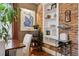 Cozy dining room detail showcasing exposed brick wall with built-in shelving at 34 W Maple Ave, Denver, CO 80223