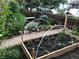 Landscaped front yard featuring a raised garden bed and decorative plants alongside a bench and fence at 34 W Maple Ave, Denver, CO 80223