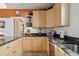Kitchen showcasing wooden cabinets, black countertops, and stainless steel sink at 34 W Maple Ave, Denver, CO 80223