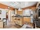 Open kitchen with island, barstools, stainless steel appliances, and tiled floor at 34 W Maple Ave, Denver, CO 80223