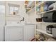 Bright laundry area featuring a washer, dryer, and built-in shelving for convenient storage solutions at 34 W Maple Ave, Denver, CO 80223