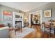 Charming living room featuring hardwood floors, a decorative fireplace, a comfortable chair, and an open floorplan at 34 W Maple Ave, Denver, CO 80223