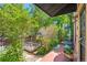 Inviting patio area surrounded by mature trees and lush plants, with a raised garden bed at 34 W Maple Ave, Denver, CO 80223