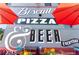 Exterior view of a restaurant with red umbrellas and lettering that says Biscuits, Pizza, and Beer at 34 W Maple Ave, Denver, CO 80223