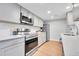Modern kitchen with stainless steel appliances, grey cabinets, and quartz countertops at 1344 Sable Blvd, Aurora, CO 80011