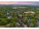 A panoramic view of the neighborhood nestled among lush trees with Denver skyline and mountains at 6901 E 12Th Ave, Denver, CO 80220