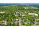 Aerial shot of a house surrounded by lush trees, a quiet neighborhood, and a mountain backdrop at 6901 E 12Th Ave, Denver, CO 80220
