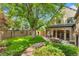 Backyard featuring a dining table, patio, mature trees, and a well-manicured lawn at 6901 E 12Th Ave, Denver, CO 80220