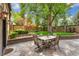 Backyard stone patio with comfortable seating and a mature tree providing shade at 6901 E 12Th Ave, Denver, CO 80220