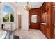 Elegant bathroom with marble floors, custom wood vanity, and large arched window at 6901 E 12Th Ave, Denver, CO 80220