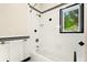 Classic tiled bathroom with a shower-tub combination and a bright window at 6901 E 12Th Ave, Denver, CO 80220