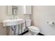 Stylish half-bathroom with modern toilet and sink, complemented by black and white patterned tile at 6901 E 12Th Ave, Denver, CO 80220