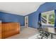 Bright blue bedroom with vaulted ceiling, built-in shelving, and large window view at 6901 E 12Th Ave, Denver, CO 80220