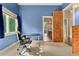 Bright blue bedroom showing doorway into an adjacent bathroom with custom wood vanity at 6901 E 12Th Ave, Denver, CO 80220