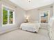 Inviting bedroom featuring carpeted floors, two windows, and a comfortable bed at 6901 E 12Th Ave, Denver, CO 80220